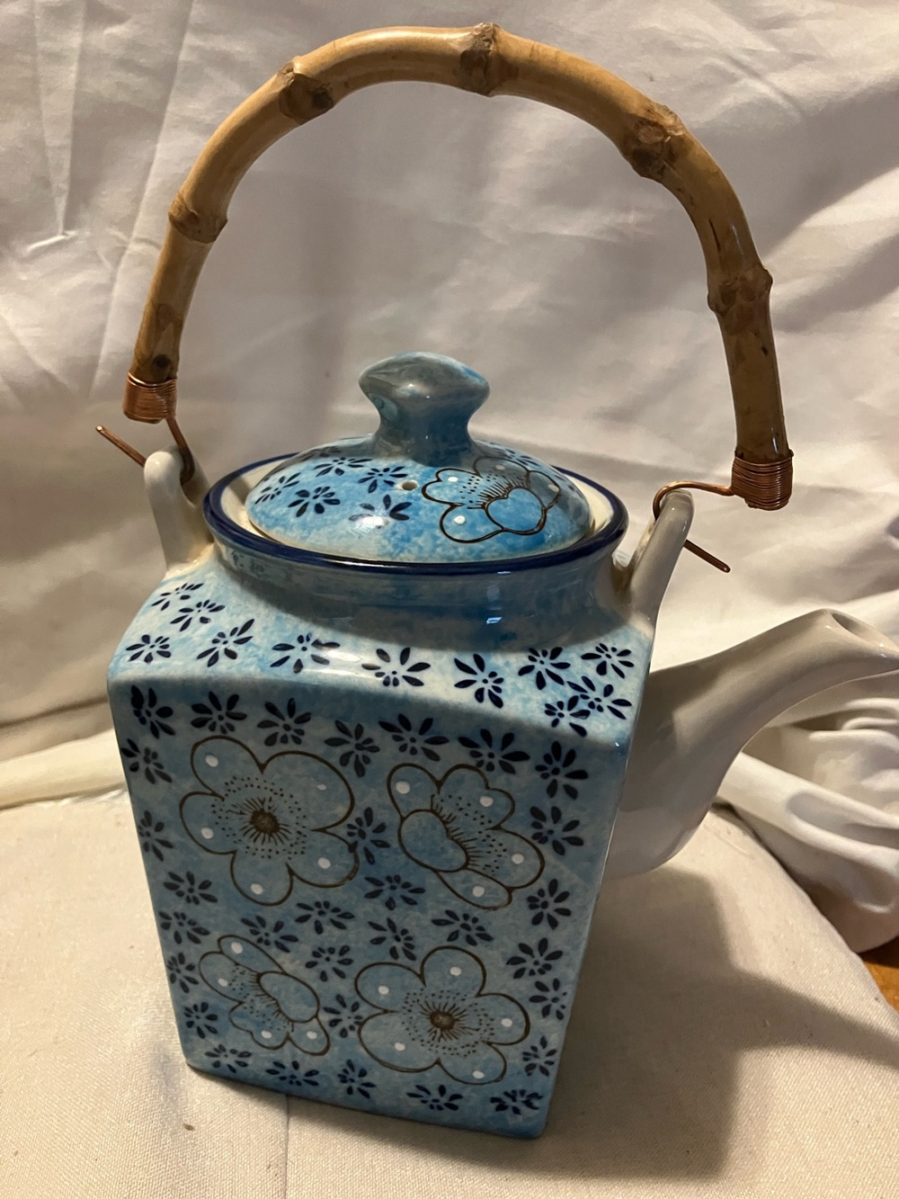 Beautiful Oriental style porcelain tea pot with bamboo handles. Has been used